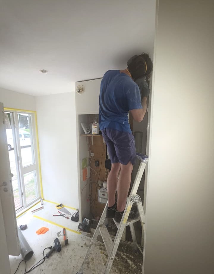 SpoedGieters monteur werkt vanaf ladder aan leidingwerk