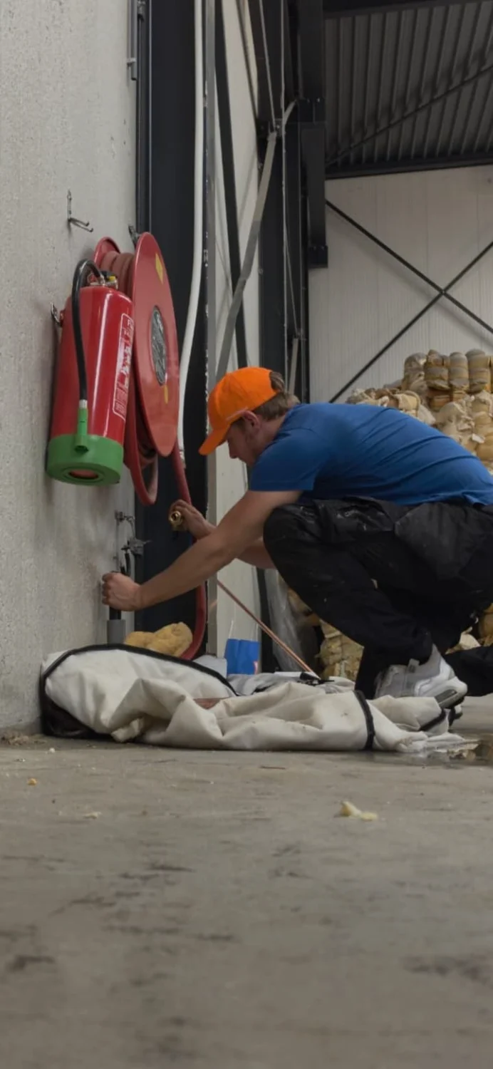SpoedGieters monteur tijdens werkzaamheden in een bedrijfsruimte