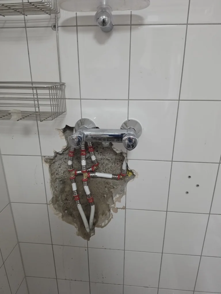 Vernieuwd leidingwerk achter de douchekraan in Doenrade.